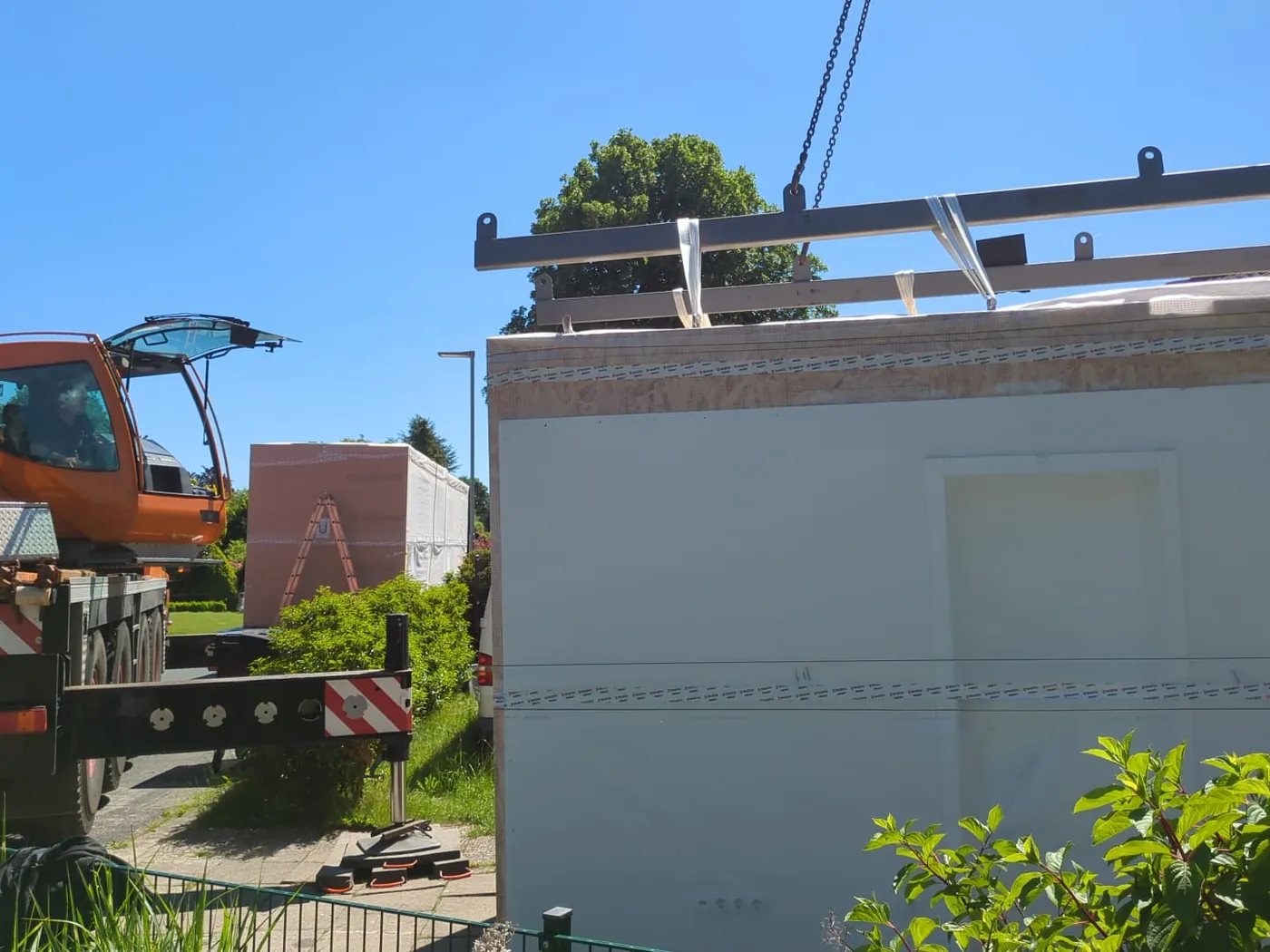 Wandelement am Kran über der Baustelle